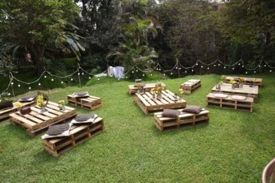Decoración para pedida de mano campestre en Lima con luces de feria y mobiliario tipo pallet. Productora Roxste."